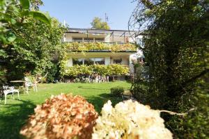 una casa con un patio con sillas y plantas en Ferienwohnung im Haus Lotus mit großem Balkon und Garten, en Bad Urach