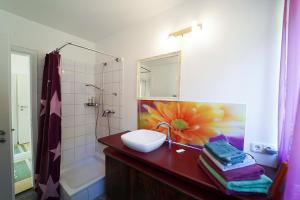 a bathroom with a sink and a flower painting on the wall at Ferienwohnung im Haus Lotus mit großem Balkon und Garten in Bad Urach +18 photos