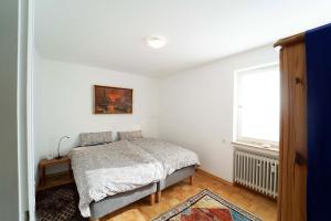 1 dormitorio con cama y ventana en Ferienwohnung im Haus Lotus mit großem Balkon und Garten, en Bad Urach