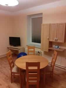 a dining room with a table and chairs and a television at Apartmán se zahradou kousek od Ještědu in Liberec