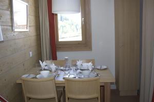 une table à manger avec des chaises, une table et une fenêtre dans l'établissement Apartment Near The Ski Slopes In La Plagne, à La Plagne Tarentaise