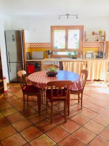 uma cozinha com uma mesa e cadeiras e um frigorífico em Rez de jardin de chalet bois , calme et verdure ! em Saint-Martin-Vésubie
