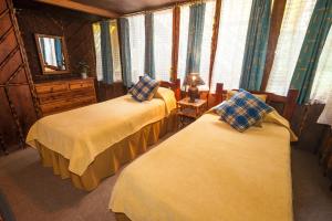 a bedroom with two beds in a room with windows at El Septimo Paraiso in Mindo