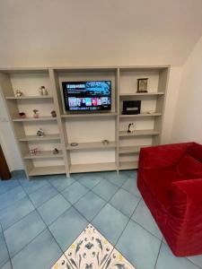 een woonkamer met een tv en een rode bank bij Atri Guest House in Napels