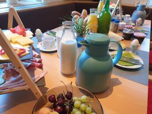 a table with a jug of milk and a bowl of fruit at Unterbiberghof in Saalfelden am Steinernen Meer