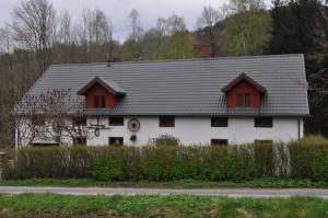 a white and red house with a clock on it at Czarnotka in Mirsk