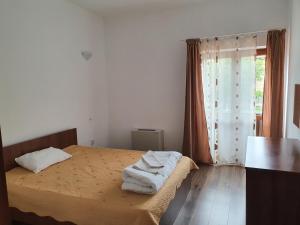 a bedroom with a bed with towels on it at PENSIUNEA ANAIS in Cîmpeni