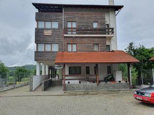 a tall brick building with a red roof at PENSIUNEA ANAIS in Cîmpeni