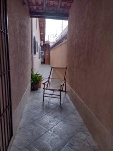 una silla sentada en un patio en un edificio en Balneário Maracanã - Praia Grande - Aceita Pet - 50 mts praia, en Praia Grande