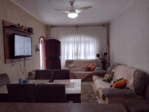 sala de estar con sofá y mesa en Balneário Maracanã - Praia Grande - Aceita Pet - 50 mts praia, en Praia Grande