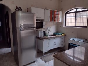 cocina con nevera de acero inoxidable y fregadero en Balneário Maracanã - Praia Grande - Aceita Pet - 50 mts praia, en Praia Grande