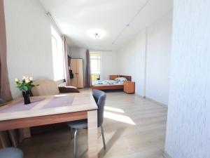 a living room with a table and a bedroom at K&K Apartments Gulliver 146 in Perm