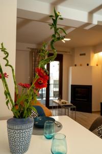 a vase with flowers on a table in a living room at Comfy & stylish apt in Ioannina with fireplace in Ioannina