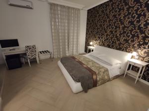 a bedroom with a large bed and a wall at SAMI Rooms - Teatro a 400 mt - Ortigia a 1500 mt - Prenotazioni solo con B00KING - Reservation only with B00KING - in Syracuse