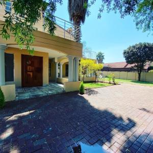 a house with a brick driveway in front of it at Selina Airport Lodge #Emzini in Kempton Park