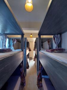 a room with three bunk beds in a house at Carmine Hotel Dahab in Dahab