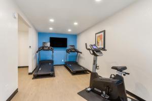 a gym with three exercise bikes and a flat screen tv at Red Lion Inn & Suites Nashville Airport in Nashville