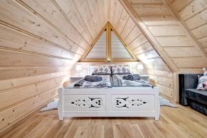 a bedroom in a log cabin with a bed in it at Domek drewniany luxury cottage Dabrowa in Zakopane