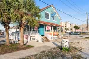 a blue building with a sale sign in front of it at Paradise in the Palms in Mexico Beach