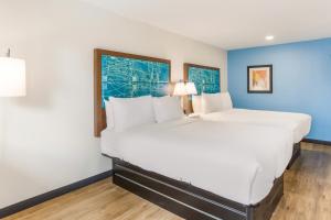 uma grande cama branca num quarto com duas janelas em Red Lion Inn & Suites Nashville Airport em Nashville