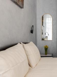 Un dormitorio con una cama blanca y un espejo. en Golden Violin ! Apartments Lviv S, en Leópolis