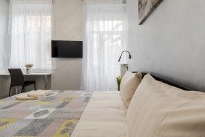 Un dormitorio con una cama con un escritorio y un televisor. en Golden Violin ! Apartments Lviv S, en Leópolis