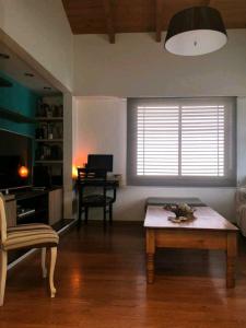 - un salon avec une table et un bureau dans l'établissement Lugar confortable y tranquilo, à Carmen de Patagones
