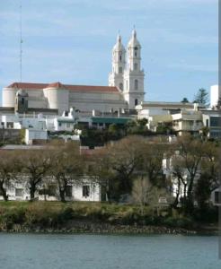 ein großes weißes Gebäude mit einer Kirche im Hintergrund in der Unterkunft Lugar confortable y tranquilo in Carmen de Patagones