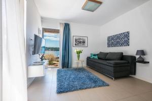 a living room with a couch and a tv at Villa del Mar Deluxe in Mali Lošinj