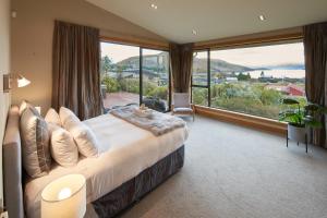 a bedroom with a large bed and a large window at Takapō Retreat - Lake Tekapo in Lake Tekapo