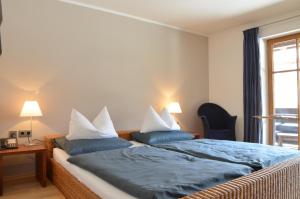a bedroom with two beds with blue and white pillows at Nebelhorn Relaxhotel in Obermaiselstein