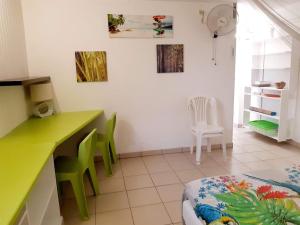 una cucina con bancone verde e sedie verdi di SAINTE-LUCE 2 T1 HIBISCUS et COLIBRIS a Sainte-Luce