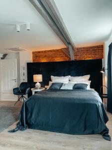 a bedroom with a large bed with a black headboard at Suite Living Boardinghouse Apartments in Gießen