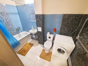 a bathroom with a toilet and a tub and a sink at K&K Apartments Gulliver 468 in Perm