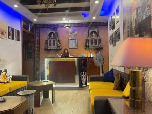 a living room with a yellow couch and a tv at The location Hotel in Cairo