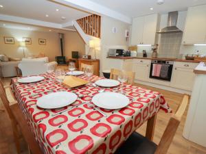 a dining room table with a red and white table cloth at The Cottage At Barrow Mead in Bath