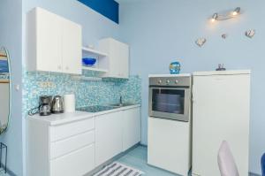  La cuisine est équipée de placards blancs et d'un réfrigérateur. dans l'établissement Apartments Zdenka, à Okrug Donji