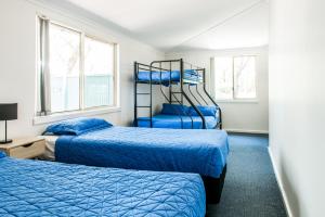 1 dormitorio con 2 camas y 2 ventanas en The Retreat Port Stephens, en Anna Bay