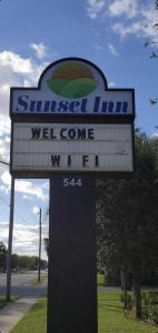 een bord voor een ontzagwekkende herberg met een welkomstbord bij Sunset Inn Daytona Beach in Daytona Beach