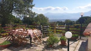 un patio con mesa, sillas y una valla en BeB Casale Pompei Rendine, en Boscotrecase
