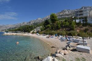 a beach with a bunch of people sitting on the beach at Apartment Anica in Omiš +17 photos