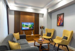 a living room with a couch and two chairs at SALA SUITES in Istanbul