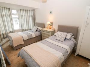 a bedroom with two beds and a dresser and a window at Avondale in Porthmadog