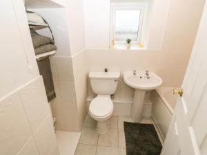 a white bathroom with a toilet and a sink at Avondale in Porthmadog +20 photos