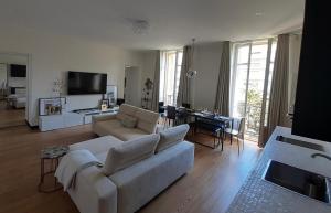 ein Wohnzimmer mit einem weißen Sofa und einem Tisch in der Unterkunft Sublime appartement centre, parc et parking in Biarritz