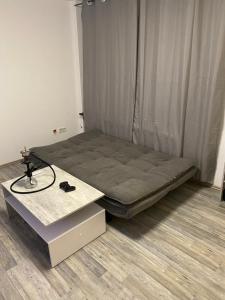 a small bed in a room with a table at Wohnen direkt an der Rheinpromenade mit Whirlpool und Sauna in Götterswickerhamm