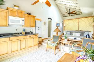 a kitchen and living room with a couch and a table at Paniolo #202B in Princeville