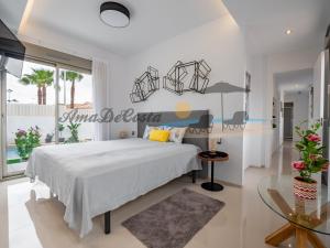 1 dormitorio con 1 cama grande y mesa de cristal en Villa Dominica en Rojales