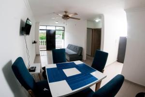 a living room with a table and blue chairs at Rodadero Apartment in Rodadero