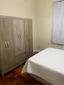 a bedroom with a bed and two wooden cabinets at Copacabana Rio praia 6 in Rio de Janeiro
